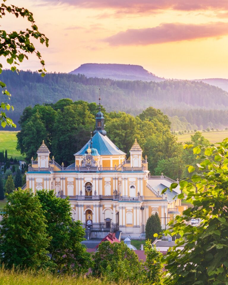 Sanktuarium w Wambierzycach w świetle zachodzącego słońca, a w tle Góry Stołowe